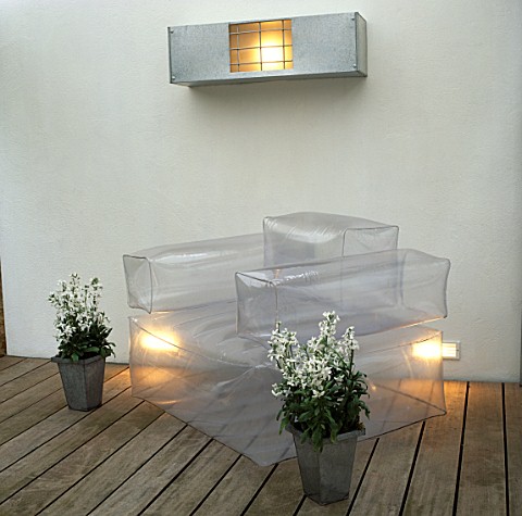 METAL_CONTAINERS_WITH_WHITE_NIGHT_SCENTED_STOCKS_STAND_BESIDE_INFLATABLE___CHAIR_ON_WOODEN_DECKING_I