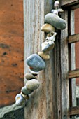STRING OF SEA-WORN PEBBLES WRAPPED AROUND A WOODEN POST IN DESIGNER STEPHEN WOODHAMS OWN ROOF GARDEN.