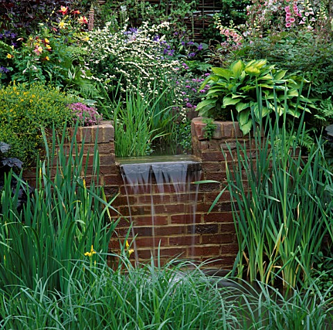 WATER_FEATURE_SMALL_WATERFALL_OVER_BRICK_WALL_INTO_LILY_POND_SURROUNDED_BY_MARGINALS