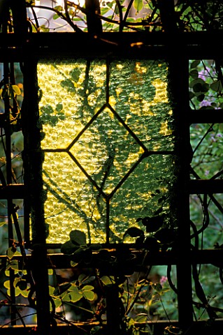 RECLAIMED_STAINED_GLASS_PANEL_SURROUNDED_BY_FOLIAGE_DESIGNER_JONATHAN_BAILLIE