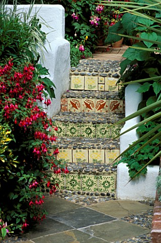 FUCHSIAS_BESIDE_STEPS_WITH_DECORATIVE_TILES_AND_PEBBLES
