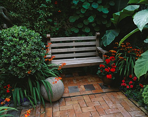 BRICK_COURTYARD_WITH_STONE_BALL__CROCOSMIA_AND_WOODEN_BENCH__DESIGN_ANDREW__KARLA_NEWELL