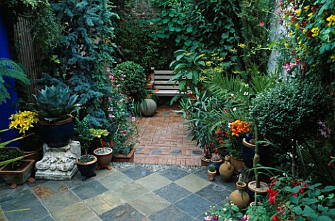 BRICK_COURTYARD_WITH_STONE_BALL__CROCOSMIA_AND_WOODEN_BENCH_IN_FOREGROUND_IS_A_TILED_FLOOR__CACTUS_A