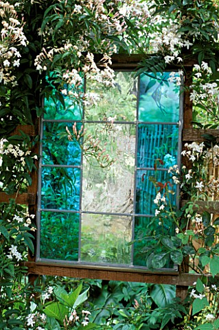 TURQUOISE_STAINED_GLASS_PANEL_BY_JOANNA_HARDING_SURROUNDED_BY_JASMINUM_OFFICINALE_DESIGNER_ALEX_JEFF