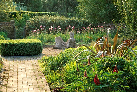 THE_HOT_GARDEN_IN_SPRING_WITH_SCULPTURE_OF_CHAC_MOOL_RAIN_GOD_BY_HELEN_SINCLAIR__IRISES_AND_LUPINS_A