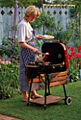 JANE NICHOLS AT THE BARBECUE IN THE NICHOLS GARDEN  READING