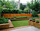 VIEW OF ITALIAN POLISHED PLASTER WALL BACKS RAISED BED WITH BOX BALLS. MODERNISTS TOWN GARDEN. DESIGNER: CHRISTOPHER BRADLEY-HOLE