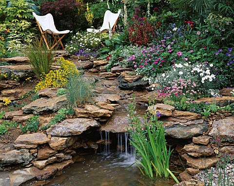 BEAUTIFUL_WATERFALL_OVER_SANDSTONE_ROCKS_WITH_PLANTING_OF_ALLIUMS__THRIFT_AND_CONVOLVULUS_CNEORUM_IN