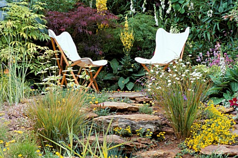 TWO_BEAUTIFUL_WHITE_CANVAS_DECKCHAIRS_SURROUNDED_BY_SANDSTONE_ROCKS_AND_MAPLES_AND_VERBASCUM_THE_VER