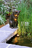 CAT SCULPTURE BY DAVID ANNAND ON A RAISED POOL WITH LIGHTING IN MR MCGREGORS GARDEN