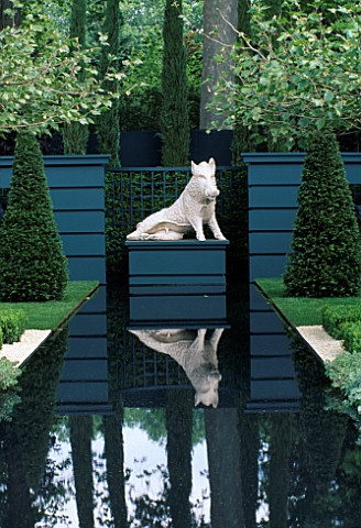RECTANGULAR_WATER_CANAL_WITH_PLINTH_AND_BOAR_SCULPTURE_SURROUNDED_BY_TOPIARY_YEWS_AND_PLATANUS_ACERI