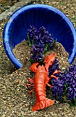 BLUE CONTAINER ON SAND WITH LOBSTER AND HYACINTH DELFT BLUE. DESIGNED BY IVAN HICKS. GROOMBRIDGE PLACE  KENT.