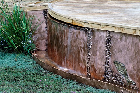 DETAIL_OF_PATTERNED_COPPER_EDGING_AND_WOODEN_DECKING_AT_THE_EDGE_OF_THE_LAWN_IN_THE_PRINCES_TRUSTPWC