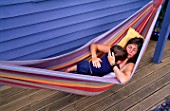 CLARE MATTHEWS RELAXES IN A HAMMOCK ON THE DECK TERRACE WITH HER SON  JOSHUA