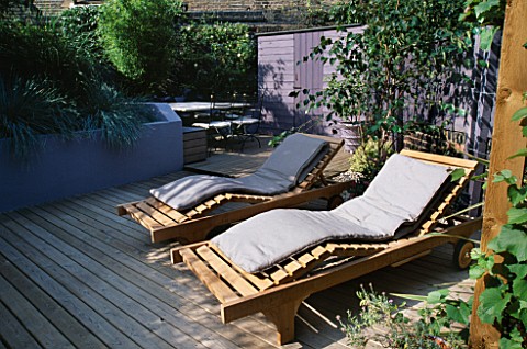 GARDEN_WITH_DECKING_DESIGNED_BY_JOE_SWIFT_AND_THAMASIN_MARSH_WOODEN_SUN_LOUNGERS_WITH_LILACGREY_FENC