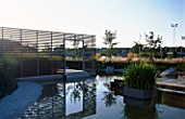 VIEW ACROSS MINIMALIST WATER GARDEN WITH FOUNTAIN AND TRANSPARENT SCREEN DESIGNED BY ULF NORDFJELL. HEDENS LUSTGARD  SWEDEN