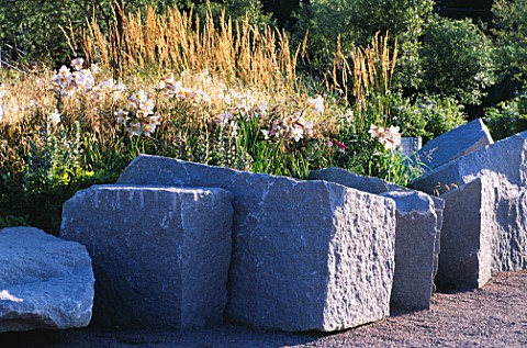 ANGULAR_ROCKS_SURROUND_MINIMALIST_GARDEN_BY_ULF_NORDFJELL_PLANTING_WITH_LILUM_REGALE_AND_DESCHAMPSIA
