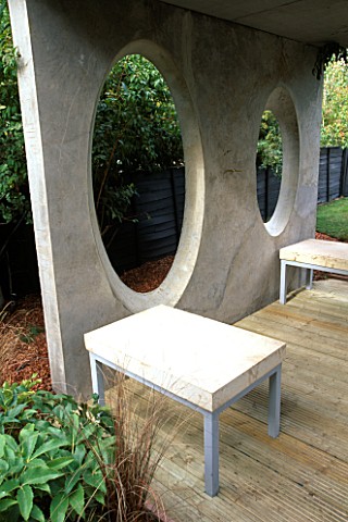 CONCRETE_ROOM_WITH_OVAL_WINDOWS__DECKED_TERRACE_AND_CONCRETE_AND_METAL_SEATS_DESIGNER_DIARMUID_GAVIN