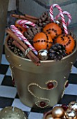 GOLD POT WITH FIR CONES  CINNAMON STICKS  CANDY CANES AND ORANGES WITH CLOVES