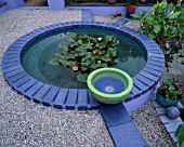BLUE CONCRETE POND SET IN GRAVEL AND PLANTED WITH WATERLILIES:  DESIGNER: CAROLE VINCENT