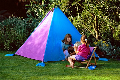 NANCY_SITS_ON_A_DECK_CHAIR_WHILST_HARRIET__JOSHUA_AND_ROBERT_LOOK_OUT_OF_THE_HOME_MADE_TENT_IN_CLARE