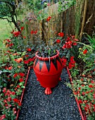 THE RED GARDEN WITH BLACK GLASS GRAVEL  RED AND BLACK POT WITH OPHIOPOGON PLANISCAPUS NIGRESCENS  RED LILIES  DAHLIA BISHOP OF LLANDAF AND ACHILLEA FANAL