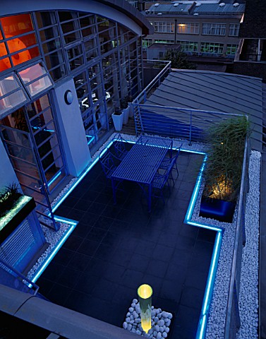 ROOF_GARDEN_DESIGNED_BY_STEPHEN_WOODHAMS_LIT_UP_AT_NIGHT_BLACK_SLATE_TERRACE_WITH_TABLE_AND_CHAIRS_A