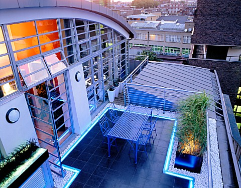 ROOF_GARDEN_DESIGNED_BY_STEPHEN_WOODHAMS_LIT_UP_AT_NIGHT_BLACK_SLATE_TERRACE_WITH_TABLE_AND_CHAIRS_A
