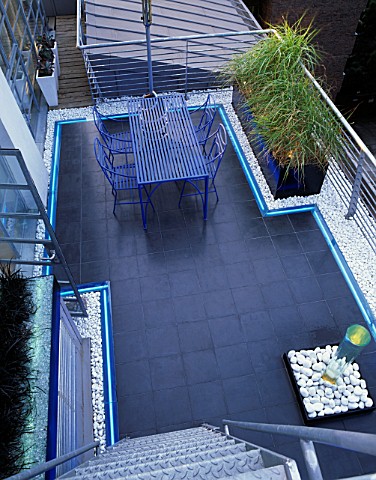 ROOF_GARDEN_DESIGNED_BY_STEPHEN_WOODHAMS_BLACK_SLATE_TERRACE_WITH_METAL_TABLE_AND_CHAIRS_AND_WATER_F