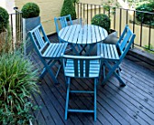 ROOF GARDEN DESIGNED BY STEPHEN WOODHAMS: DECKED TERRACE WITH BLUE TABLE AND CHAIRS AND METAL CONTAINERS PLANTED WITH BOX