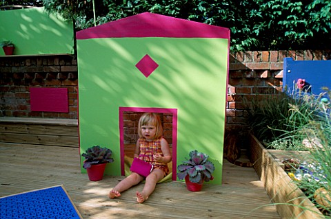 CHILDRENS_DECK_GARDEN_LUCY_PLAYS_OUTSIDE_THE_FOLDAWAY_WENDY_HOUSE_ON_THE_DECK_WITH