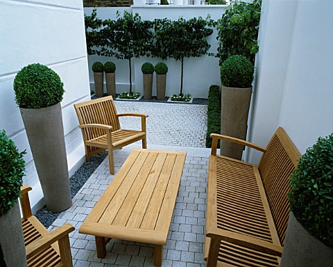 A_PLACE_TO_SIT_WOODEN_TABLE_AND_CHAIRS__ICE_WHITE_SAWN_GRANITE_SETTS_AND_EARTHENWARE_POTS_PLANTED_WI