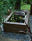 RAISED WOODEN POND WITH WATERLILIES AND SLATE WATER FEATURE. DESIGN BY GEO DESIGNS