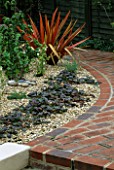 BRICK PATH WITH GRAVEL  AJUGA AND PHORMIUMS. DESIGNED BY GEO DESIGNS