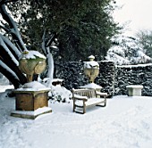 SNOW COVERED BENCH AND URNS IN THE GARDEN AT CHISWICK HOUSE   LONDON