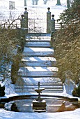 SNOW COVERS THE ORNAMENTAL POOL AND STONE STEPS AT CORNWELL MANOR  OXFORDSHIRE