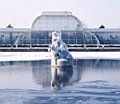 SNOW AND ICE COVERS THE FOUNTAIN AND LAKE IN FRONT OF THE PALM HOUSE. KEW GARDENS  LONDON