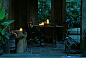 INSIDE OF THE INDONESIAN GAZEBO WITH WOODEN HAND CHAIRS  TABLE AND CHAIRS  AND CANDLES. DESIGNERS: ILGA JANSONS AND MIKE DRYFOOS