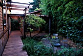 VIEW OF HOUSE WITH DECKING  BAMBOOS  METAL CHAIRS AND GLASS TABLE: DESIGNER BOB SWAIN  SEATTLE  USA