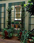 COURTYARD WITH DECKING  MIRROR  TRELLIS AND BRICK WALL. DESIGNER: CLAIRE MEE