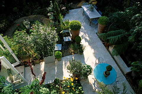 VIEW_ONTO_SMALL_GARDEN_WITH_ITALIAN_HARD_LIMESTONE_FLOOR_AND_TABLE__BLUE_CAFE_CHAIRS__WATER_FEATURE_