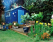 COLOURFUL BORDERS AND BLUE SUMMERHOUSE WITH DECKING IN ROSEMARY PEARSONS GARDEN  READING