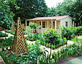 FAMILY POTAGER BY CLARE MATTHEWS: OBELISKS  CLIPPED BOX AND BAY AND A SUMMERHOUSE