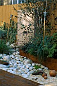 ROOF GARDEN WITH BAMBOO FENCING   WHITE BOULDERS  BARLEYCORN GRAVEL  RED CEDAR DECKING AND WATER FEATURE: DESIGN BY ALISON WEAR ASSOCIATES