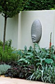 SANCTUARY GARDEN SPONSORED BY MERRILL LYNCH AT THE CHELSEA FLOWER SHOW 2002: DESIGNED BY STEPHEN WOODHAMS: ONE OF THE FIVE FACE SCULPTURES BY STEPHEN COX
