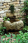 STONE TROUGH WATER FEATURE SET INTO DRY STONE WALL IN THE HERB SOCIETYS GARDEN  CHELSEA 2003. GARDEN DESIGNED BY CHERYL WALLER