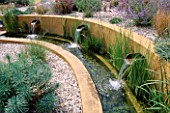 WATER FEATURE: GRAVEL GARDEN WITH WATER RILL   RENDERED CONCRETE WALLS AND THREE SPOUTS. DESIGNER: MARK LAURENCE