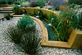 WATER FEATURE: GRAVEL GARDEN WITH WATER RILL   RENDERED CONCRETE WALLS AND THREE SPOUTS. DESIGNER: MARK LAURENCE