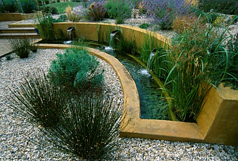 WATER_FEATURE_GRAVEL_GARDEN_WITH_WATER_RILL___RENDERED_CONCRETE_WALLS_AND_THREE_SPOUTS_DESIGNER_MARK
