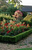 THE PRIORY  BEECH HILL  BERKSHIRE: EVENING SUNLIGHT ON THE ROSE GARDEN  WITH WOODEN ARCH PLANTED WITH AN AMERICAN PILLAR ROSE IN THE BACKGROUND